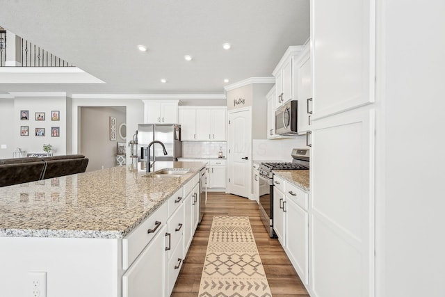 kitchen with sink, white cabinetry, a spacious island, and appliances with stainless steel finishes