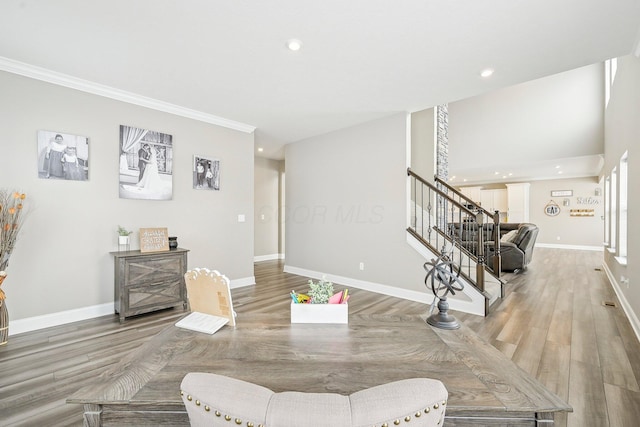 dining space featuring wood-type flooring and ornamental molding