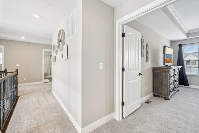 hall with light colored carpet and crown molding