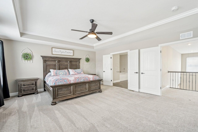 bedroom with light carpet, ornamental molding, a raised ceiling, ceiling fan, and ensuite bathroom