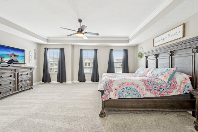 carpeted bedroom featuring ornamental molding, multiple windows, ceiling fan, and a raised ceiling