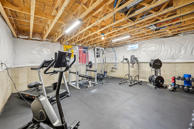 workout room featuring brick wall