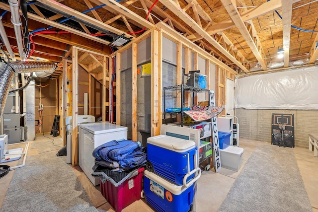 basement featuring heating unit, fridge, and washer and dryer