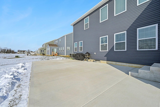 snow covered property with central AC unit