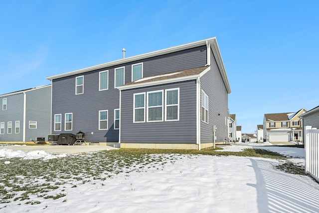 snow covered rear of property with central AC