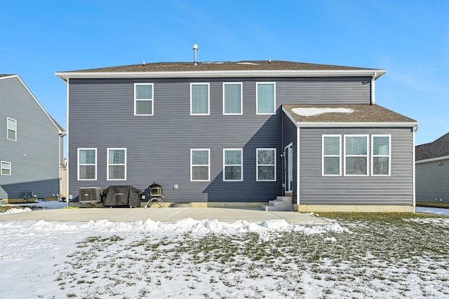 snow covered property featuring central AC unit