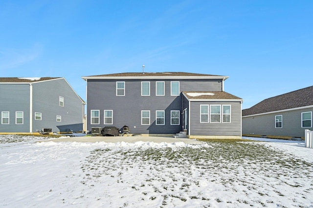 snow covered property featuring central AC