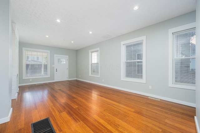 interior space featuring a textured ceiling and wood-type flooring