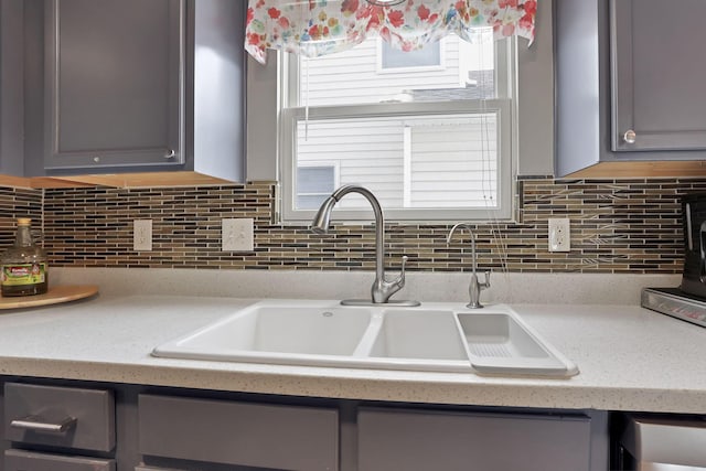 kitchen with sink, gray cabinets, and tasteful backsplash