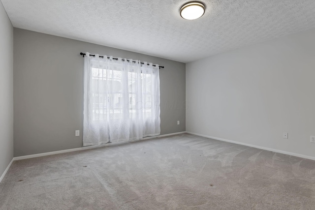 carpeted empty room with a textured ceiling