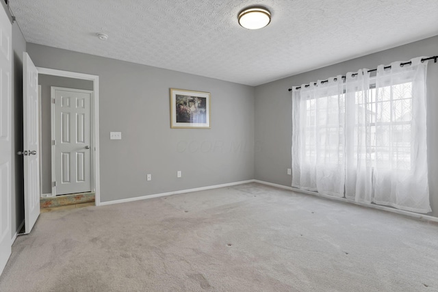 carpeted spare room featuring a textured ceiling