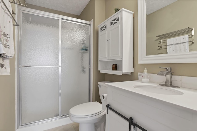 bathroom with a textured ceiling, walk in shower, vanity, and toilet