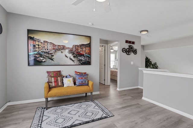 sitting room with light wood-type flooring and ceiling fan