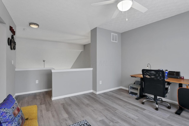 home office featuring ceiling fan, a textured ceiling, and light wood-type flooring