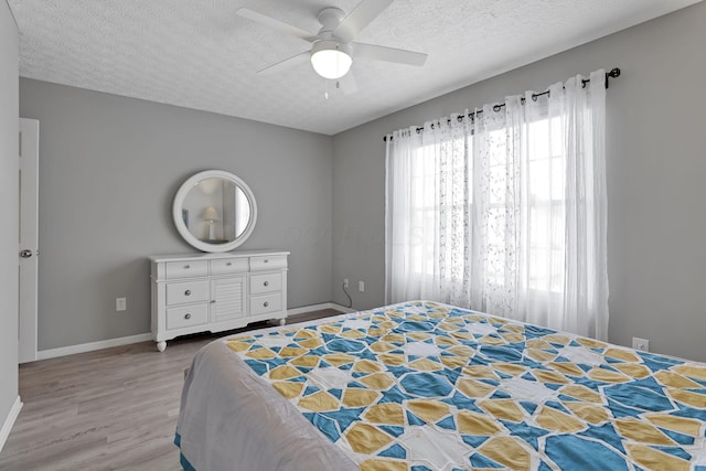 bedroom featuring ceiling fan, a textured ceiling, and wood-type flooring