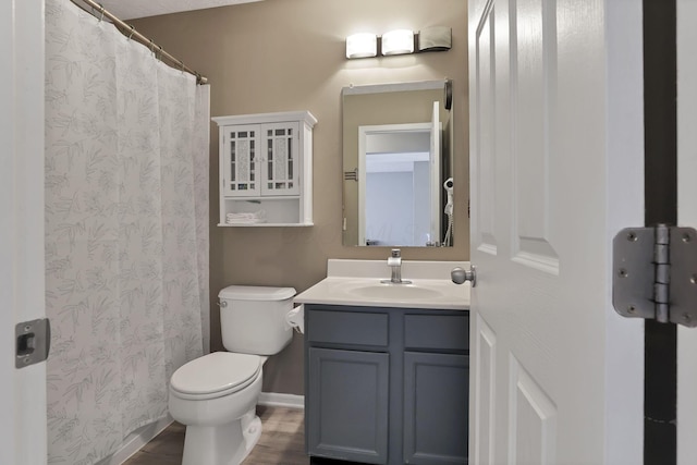 bathroom featuring wood-type flooring, toilet, and vanity