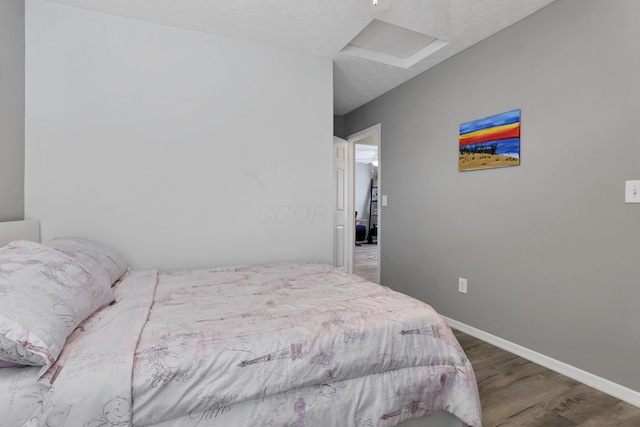 bedroom featuring hardwood / wood-style floors and a textured ceiling