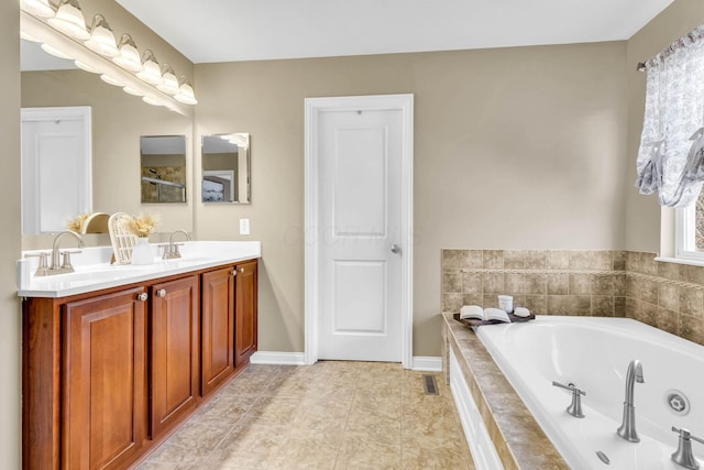 bathroom with a whirlpool tub, double vanity, baseboards, and a sink