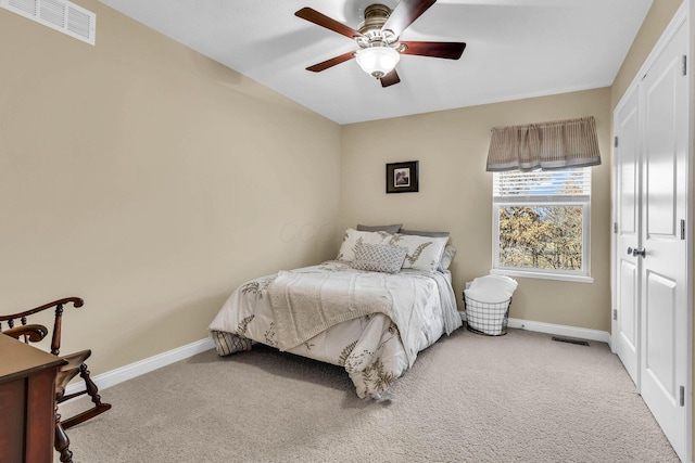 bedroom with light carpet, a ceiling fan, visible vents, and baseboards