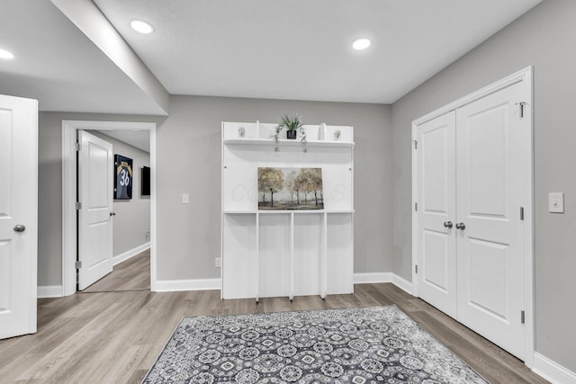 interior space featuring baseboards, wood finished floors, and recessed lighting