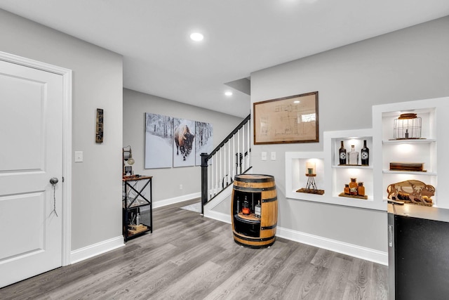 entryway with stairway, recessed lighting, wood finished floors, and baseboards