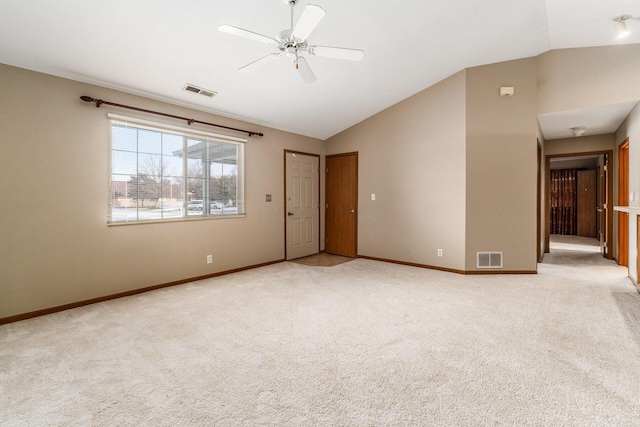 unfurnished room with light colored carpet, vaulted ceiling, and ceiling fan