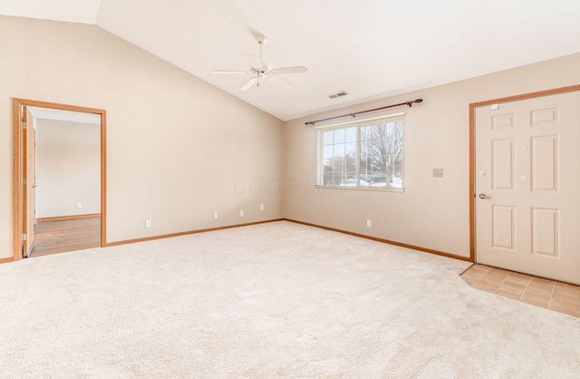 spare room featuring light colored carpet, vaulted ceiling, and ceiling fan