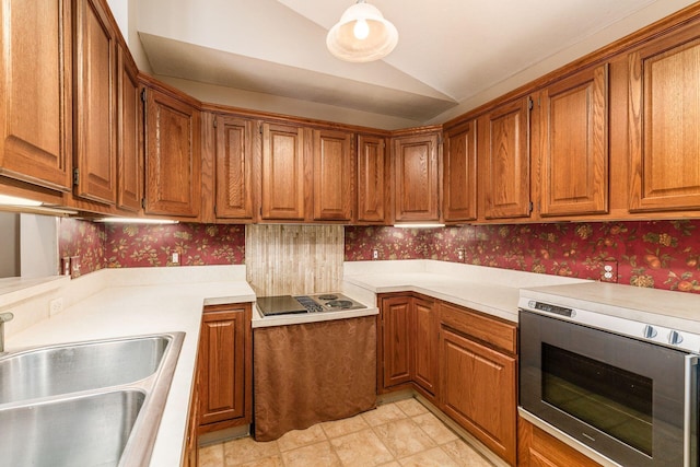 kitchen featuring sink, stainless steel microwave, black electric stovetop, and lofted ceiling