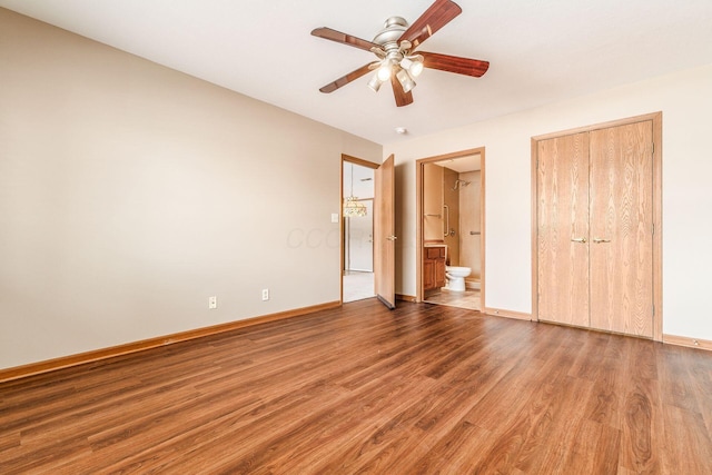 unfurnished bedroom with wood-type flooring, ensuite bathroom, a closet, and ceiling fan