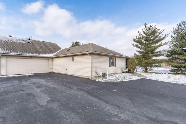 view of side of property with a garage and central AC unit