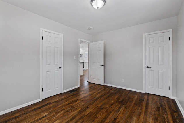 unfurnished bedroom featuring dark hardwood / wood-style floors