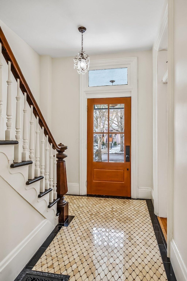 tiled foyer featuring an inviting chandelier