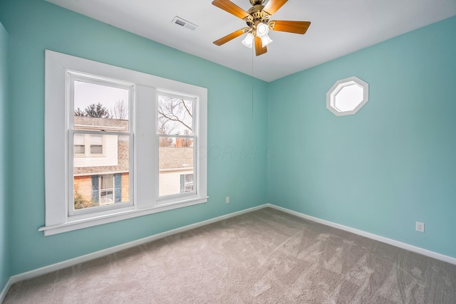 carpeted spare room with ceiling fan