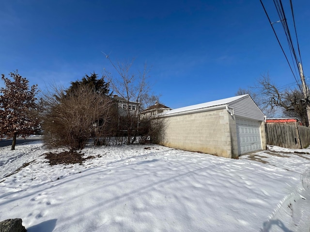 yard covered in snow featuring a garage