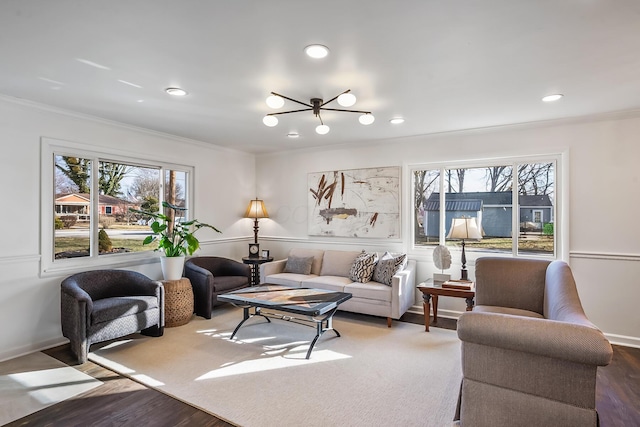 living room featuring ornamental molding, a healthy amount of sunlight, and wood-type flooring