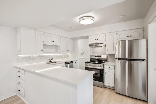 kitchen featuring sink, light hardwood / wood-style flooring, appliances with stainless steel finishes, white cabinetry, and kitchen peninsula