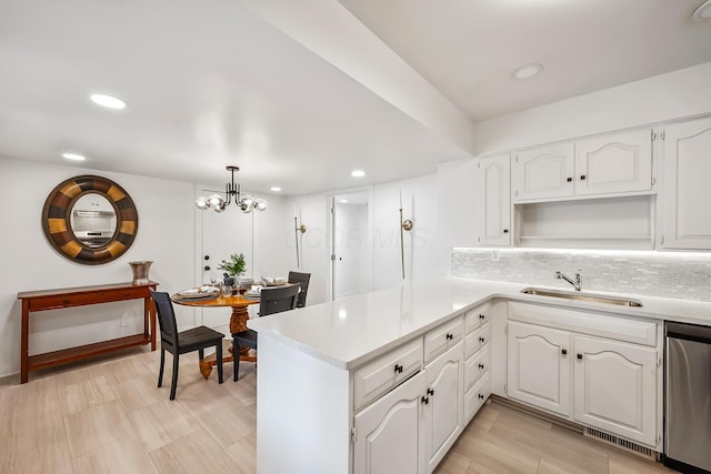 kitchen with white cabinetry, sink, decorative light fixtures, and dishwasher