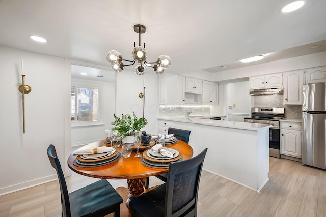 dining room featuring light hardwood / wood-style floors, sink, and a notable chandelier