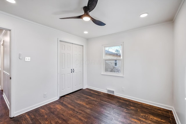 unfurnished bedroom featuring ornamental molding, dark hardwood / wood-style floors, ceiling fan, and a closet