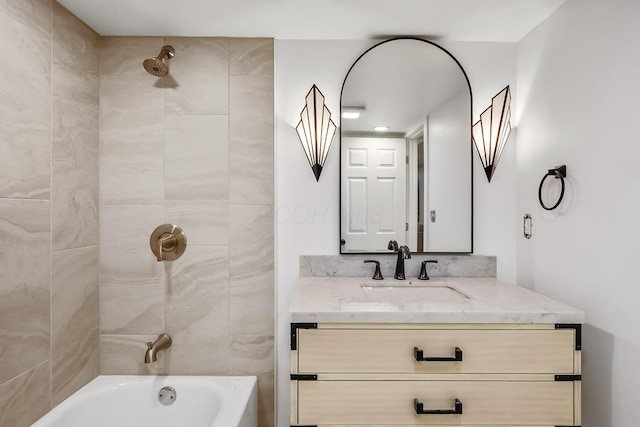 bathroom featuring vanity and tiled shower / bath