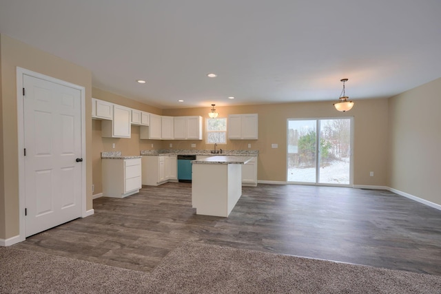 kitchen with hanging light fixtures, stainless steel dishwasher, white cabinets, a kitchen island, and dark hardwood / wood-style floors