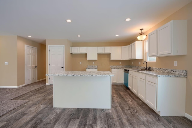 kitchen with a kitchen island, white cabinets, sink, and hanging light fixtures