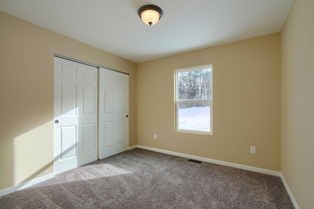 unfurnished bedroom with carpet flooring and a closet