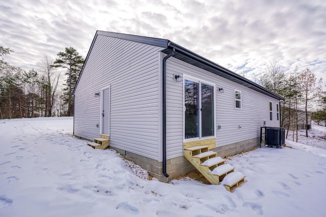 snow covered property featuring cooling unit