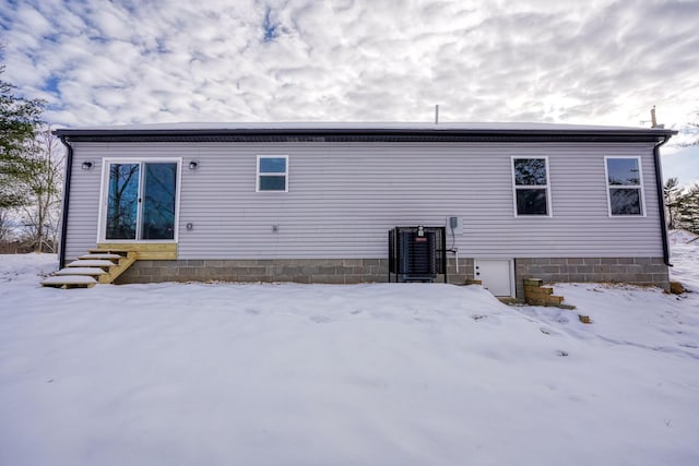 snow covered house with central air condition unit