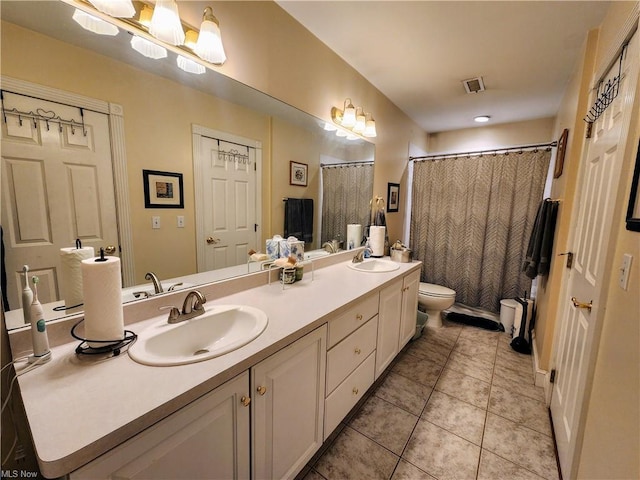 bathroom with tile patterned floors, vanity, toilet, and curtained shower