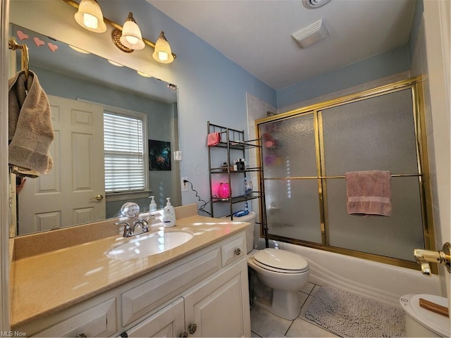 full bathroom featuring tile patterned flooring, vanity, shower / bath combination with glass door, and toilet