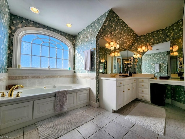 bathroom featuring a chandelier, vanity, a bathing tub, and tile patterned flooring