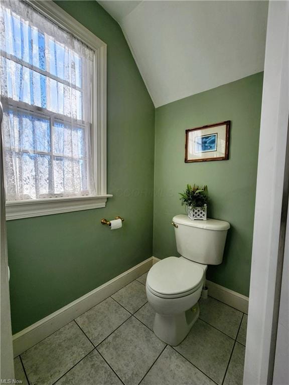 bathroom with vaulted ceiling, tile patterned floors, and toilet