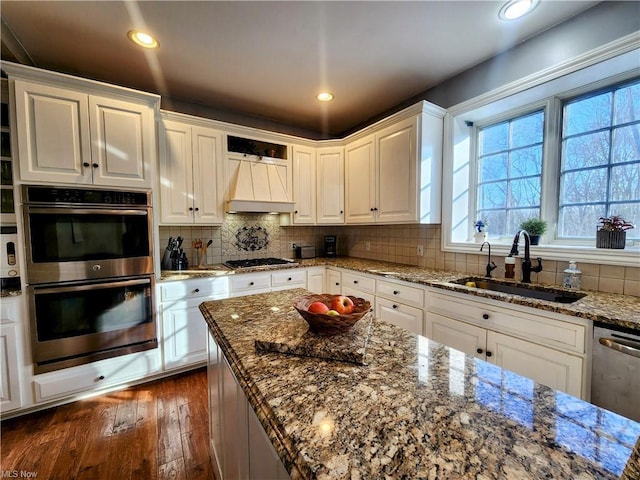 kitchen featuring stone countertops, sink, white cabinets, decorative backsplash, and stainless steel appliances